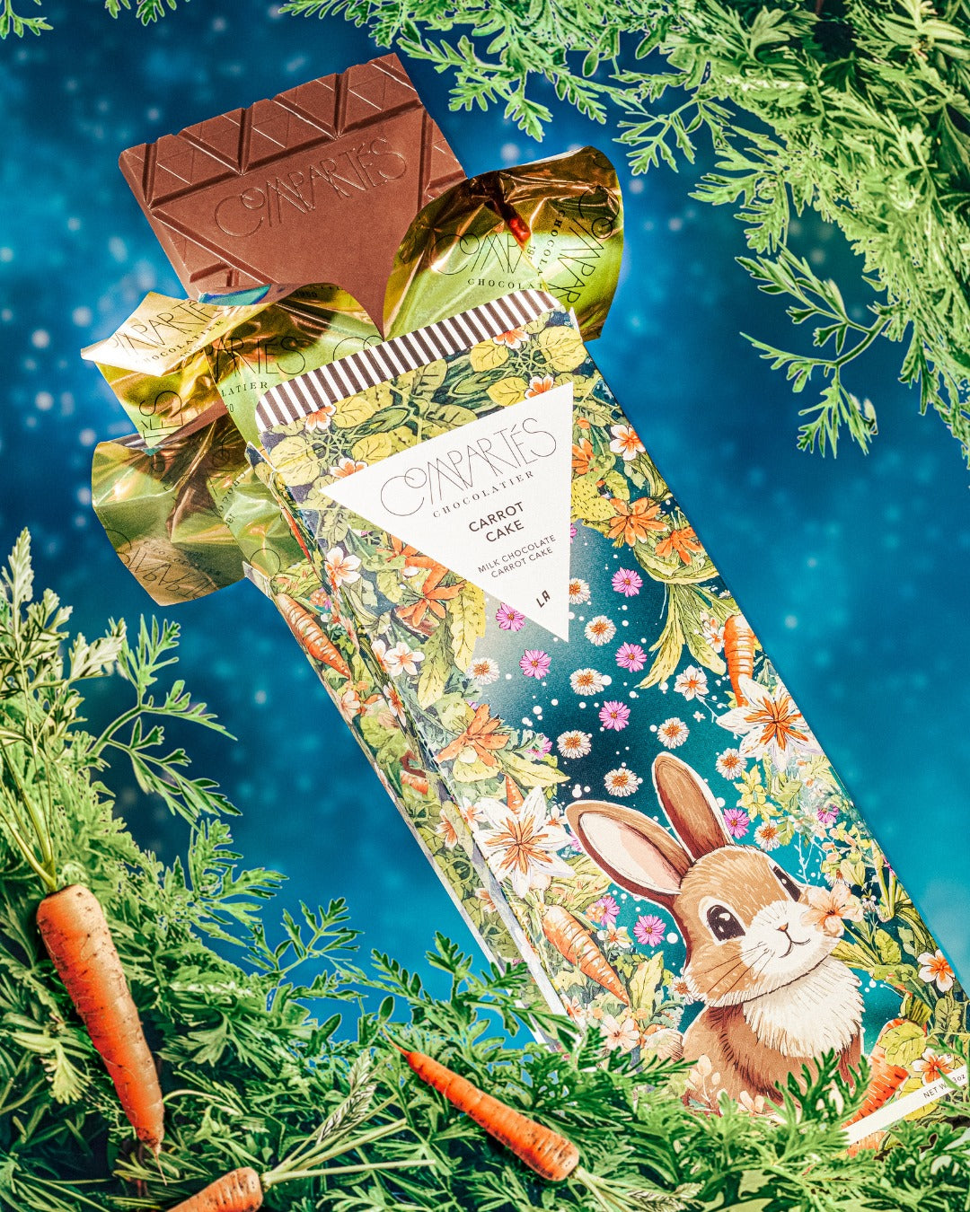 Milk Chocolate bar with Carrot Cake flavor with decorative packaging featuring a rabbit design on a blue background with greenery.