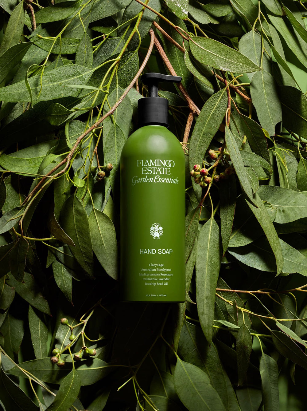 Green bottle of Garden Essentials Flamingo Estate hand soap on a leafy background