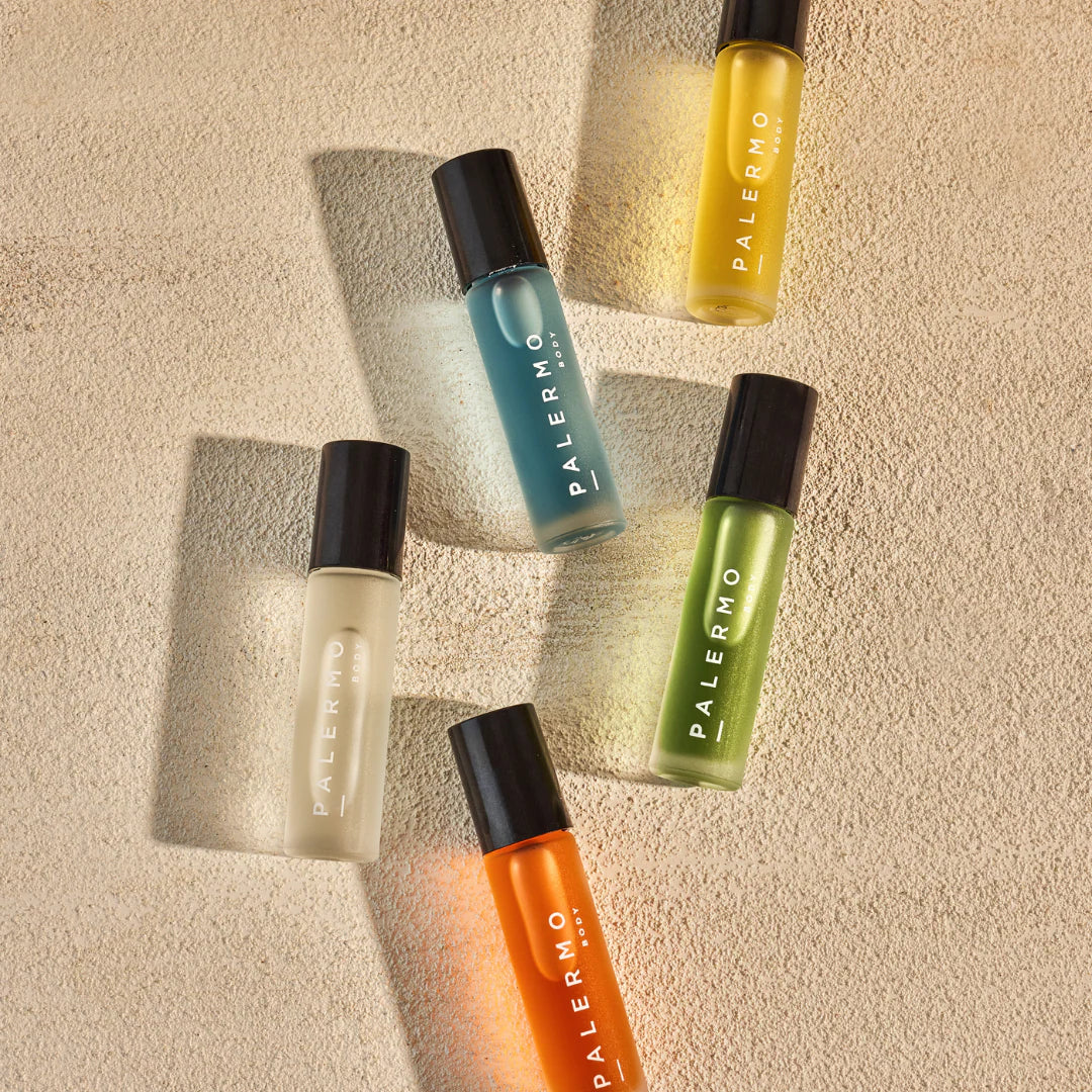 Five small bottles from Palermo natural essential oil collection for balance and relaxation, on a textured beige surface