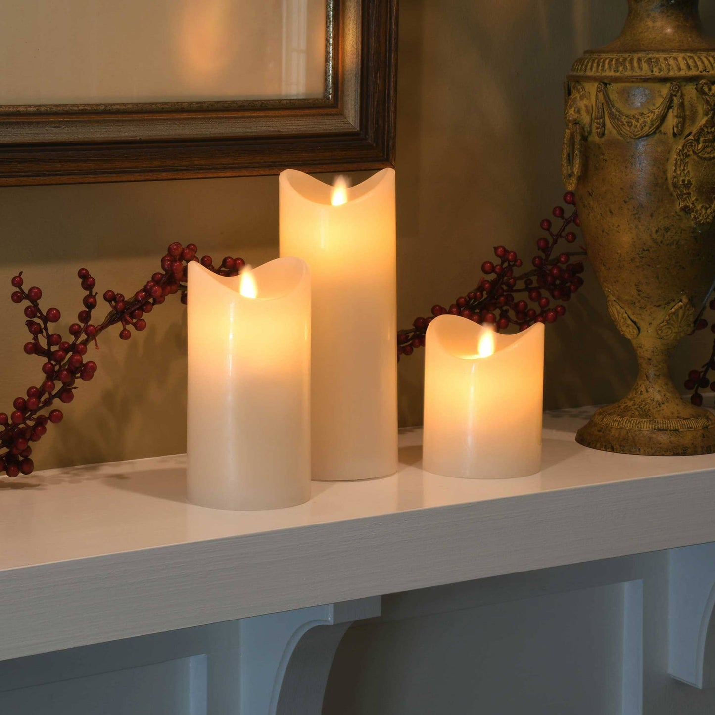 Three lit flameless battery operated candles on a surface with decorative elements including berries and an ornate vase, making up a nice home decor.