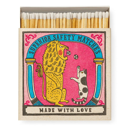 A box of safety matches featuring a fun illustration of a lion and a cat on a pink background with the text 'SUPERIOR SAFETY MATCHES' and 'MADE WITH LOVE'.