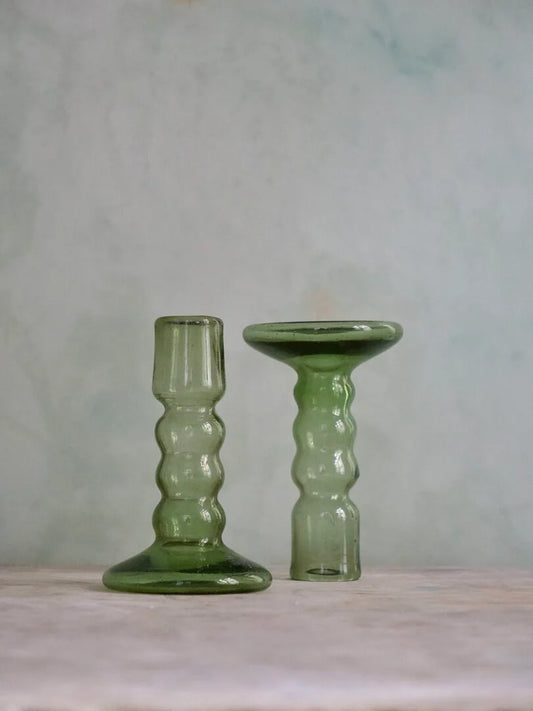 Two green glass candle holders shaped with bubbles on a neutral background