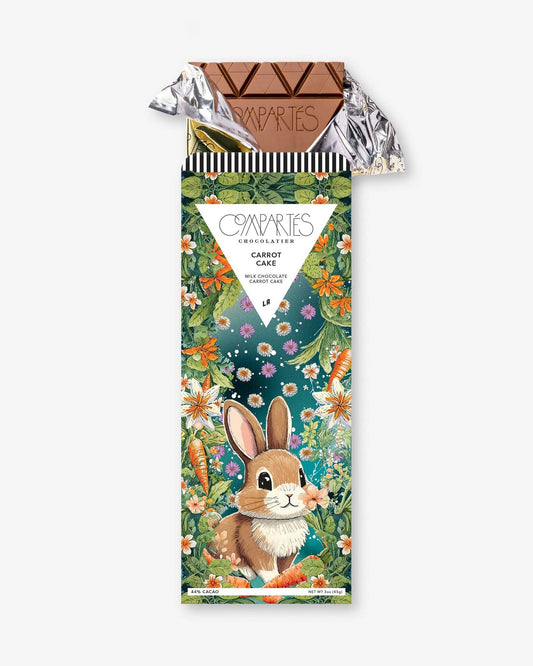 A gourmet chocolate bar with a colorful wrapper featuring an illustration of a rabbit and carrots, indicating a carrot cake flavor.