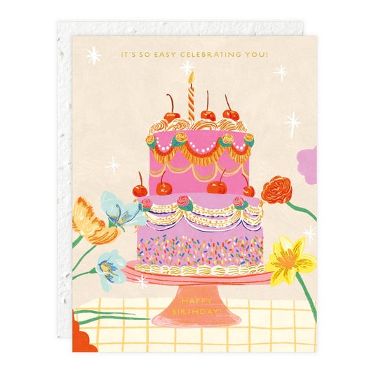 Greeting card with a colorful birthday cake illustration and flowers on a beige background.