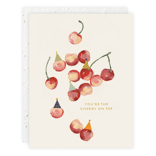 A greeting card with an illustration of cherries wearing party hats, with a text that reads 'You're the cherry on top'.