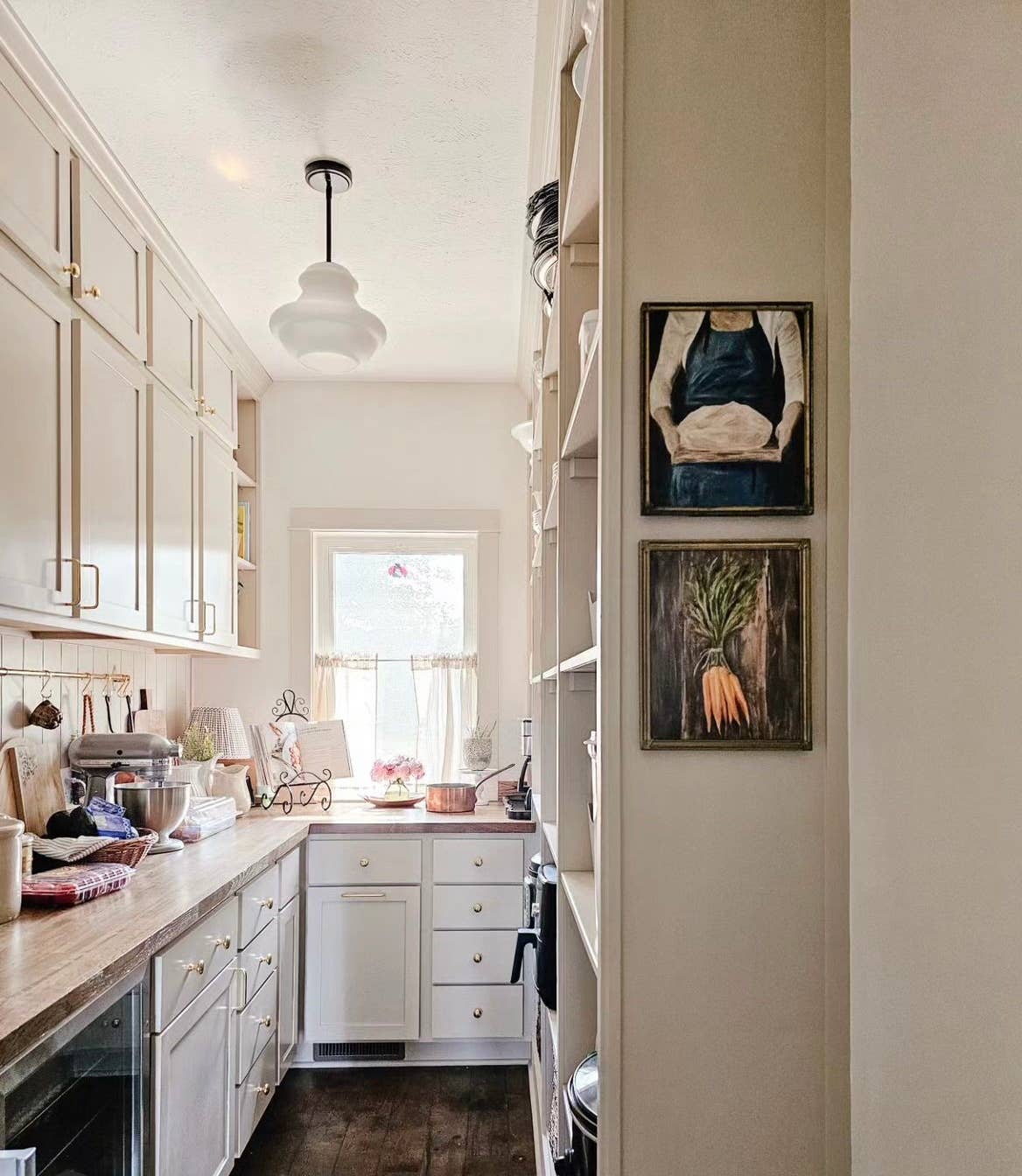French-inspired art print of a woman holding sourdough bread, here hanged on a kitchen wall.