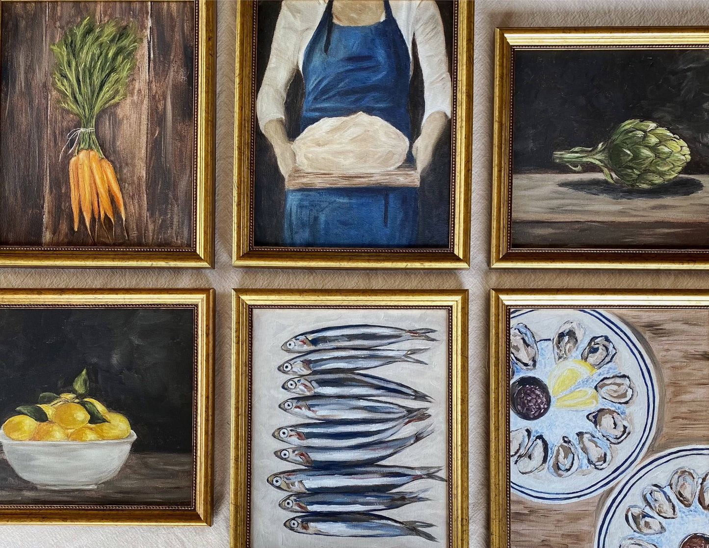 French-inspired art print of a woman holding sourdough bread, here hanged on a kitchen wall, with other various art prints.