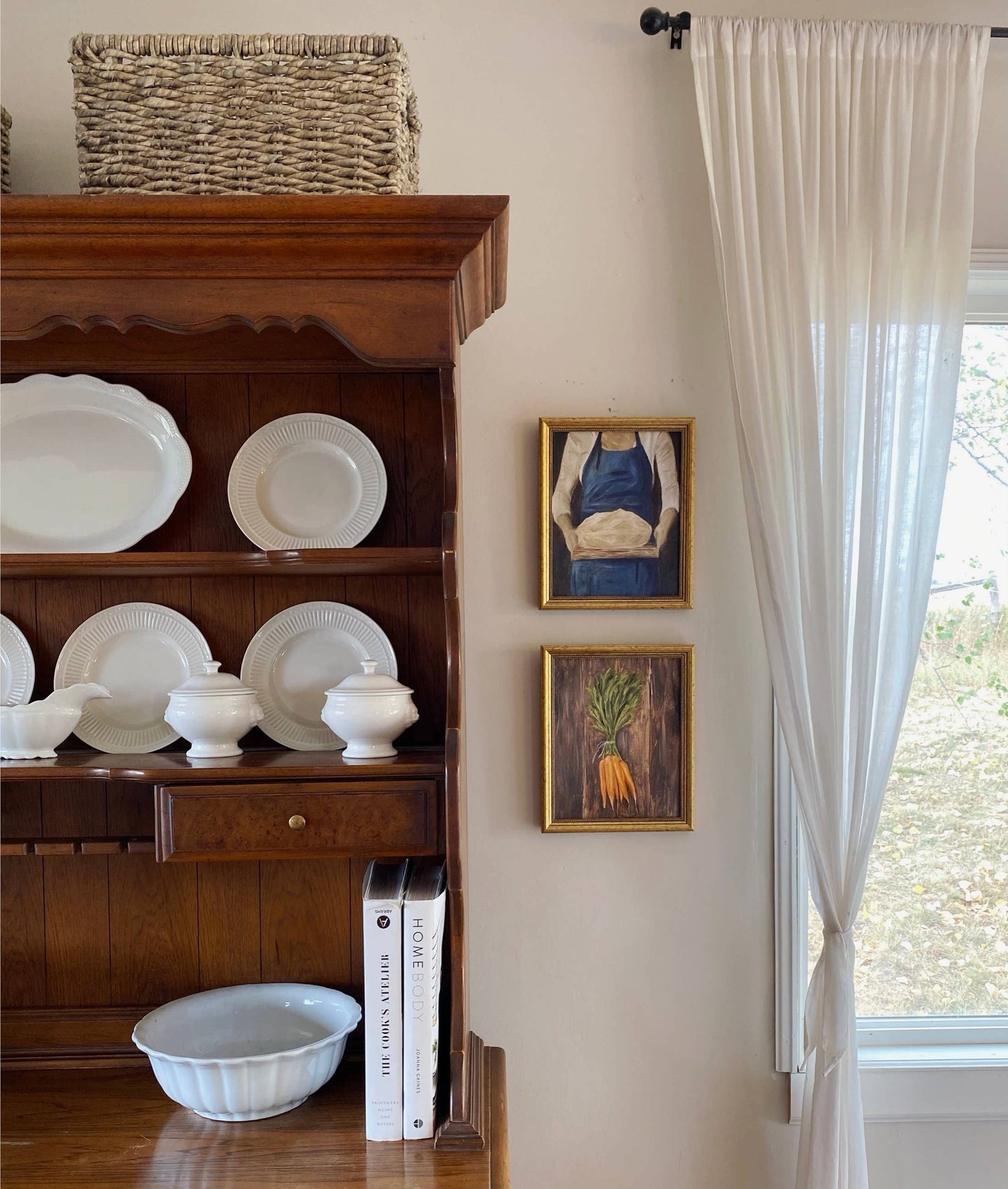 French-inspired art print of a woman holding sourdough bread, here hanged on a kitchen wall, next to a dresser.