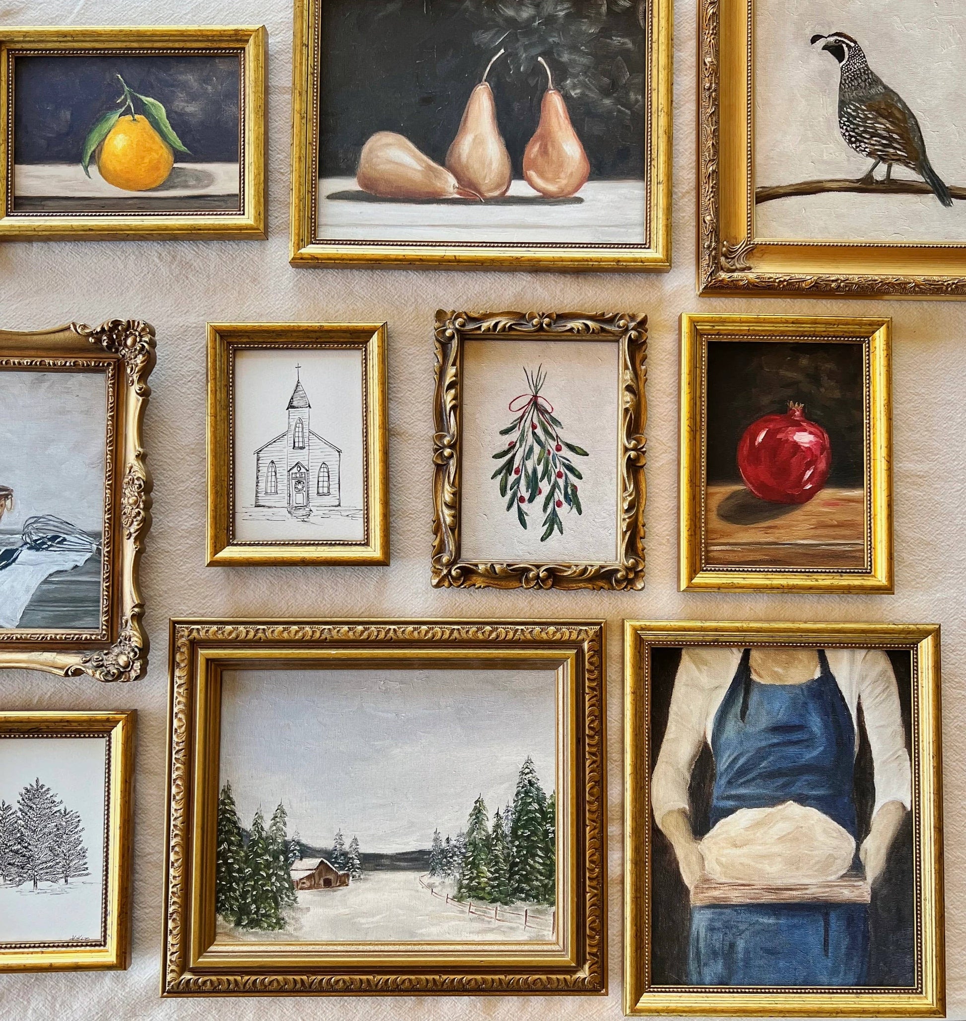 French-inspired art print of a woman holding sourdough bread, here hanged on a kitchen wall, with other various art prints.