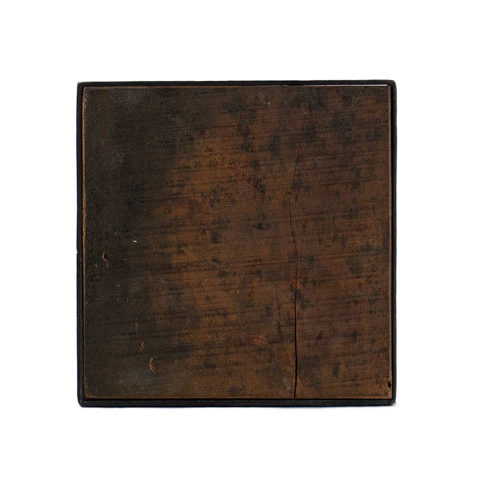 Black iron display riser with wood top, viewed from the top.