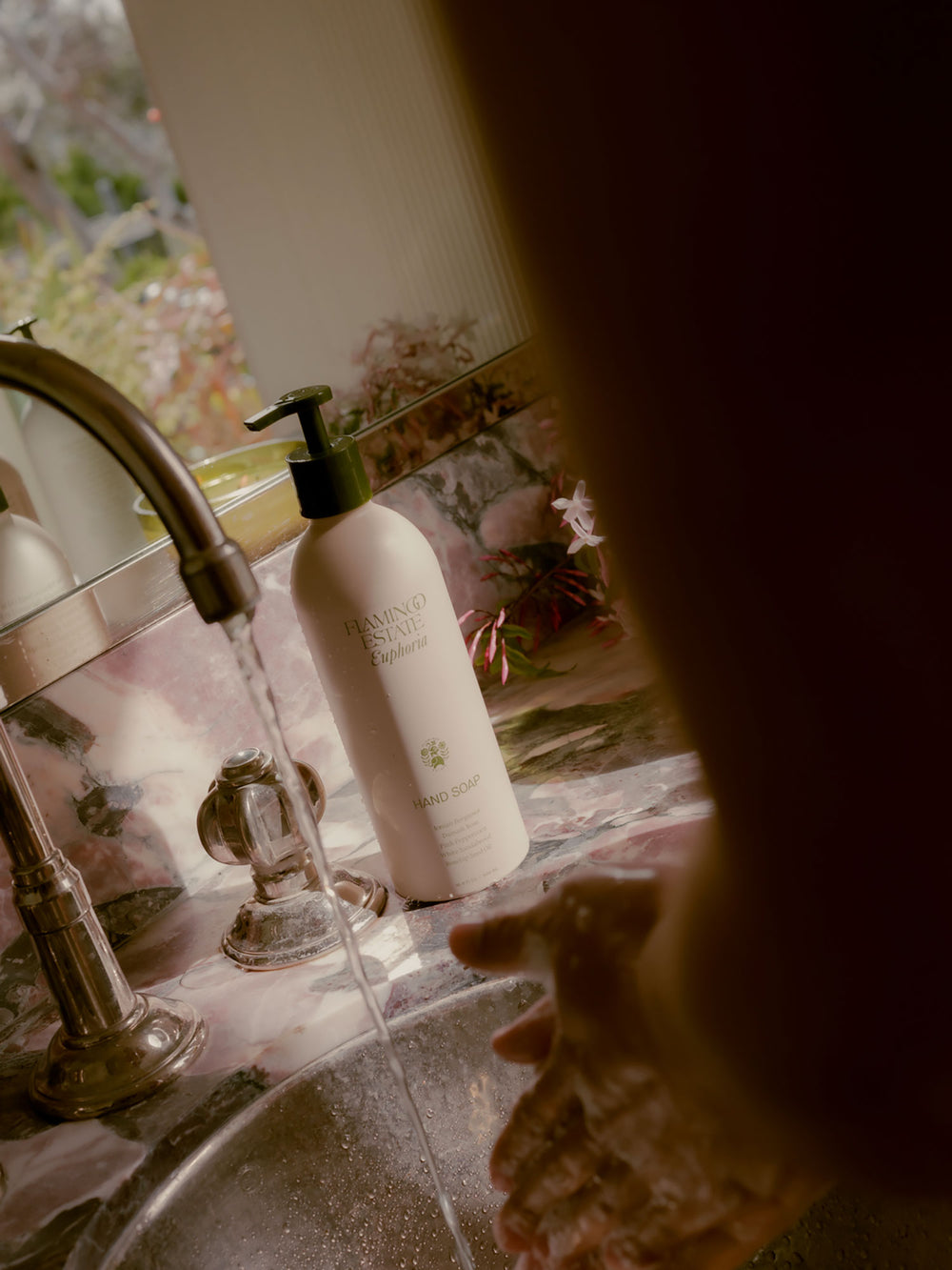 Euphoria Flamingo Estate Hand soap bottle on a kitchen counter with a blurred background