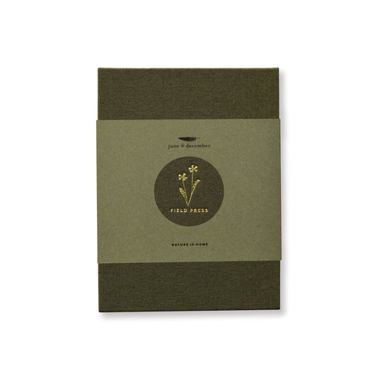 A green linen-covered field flower press with gold foil details by June & December.