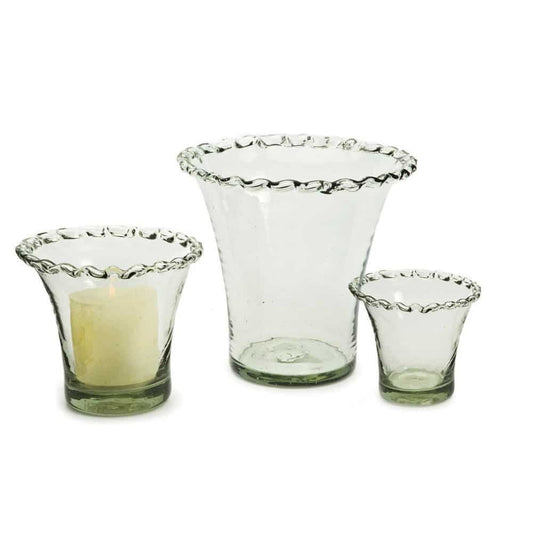 Three clear glass candle holders or vases with a pie crust shape on a white background
