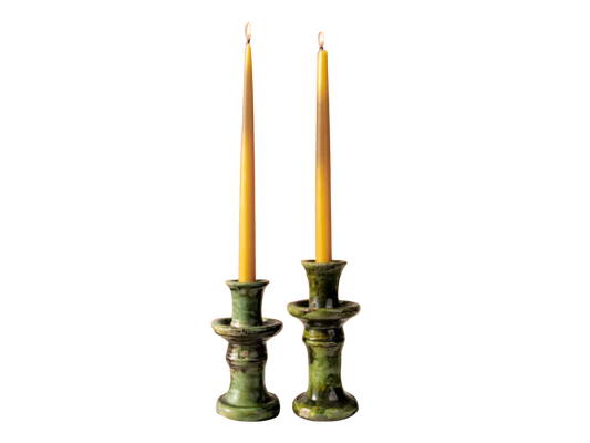 Two green tamegroute candle holders with candles on a white background
