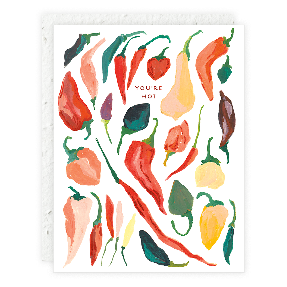 Greeting card with illustrated various types of red and multicolored chili peppers, and the text 'YOU'RE HOT' at the top. The card is placed against a white background.