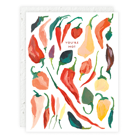 Greeting card with illustrated various types of red and multicolored chili peppers, and the text 'YOU'RE HOT' at the top. The card is placed against a white background.