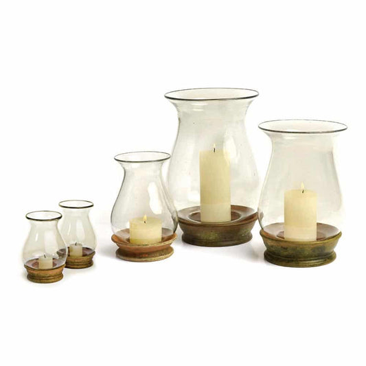 Set of glass candle holders with candles on a white background