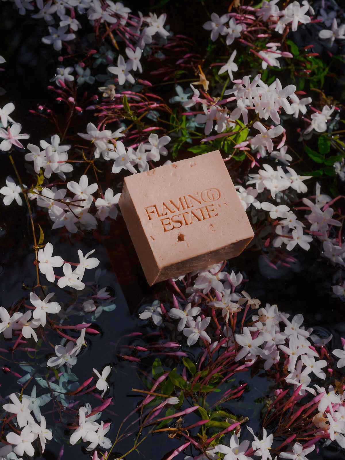 Flamingo Estate Jasmine & Rose soap bar on a bed of jasmine flowers