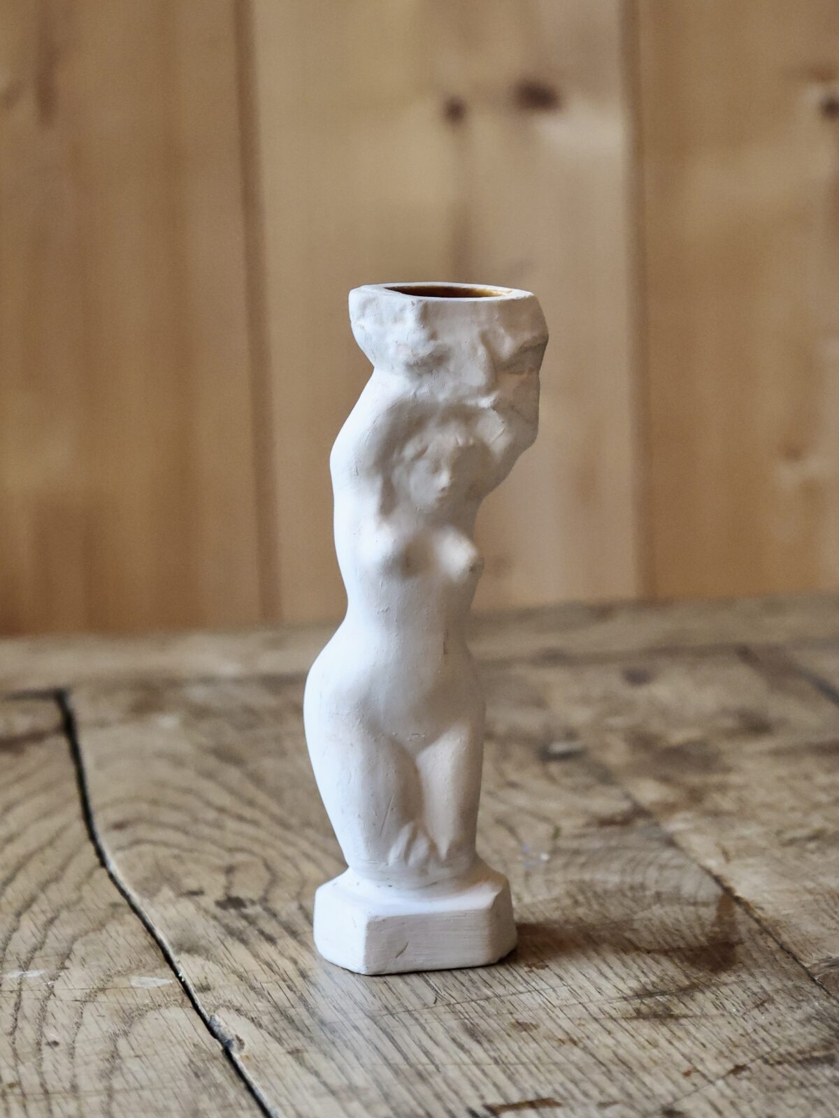 Elegant and artistic French white terracotta bud vase shaped like a female figure on a wooden surface