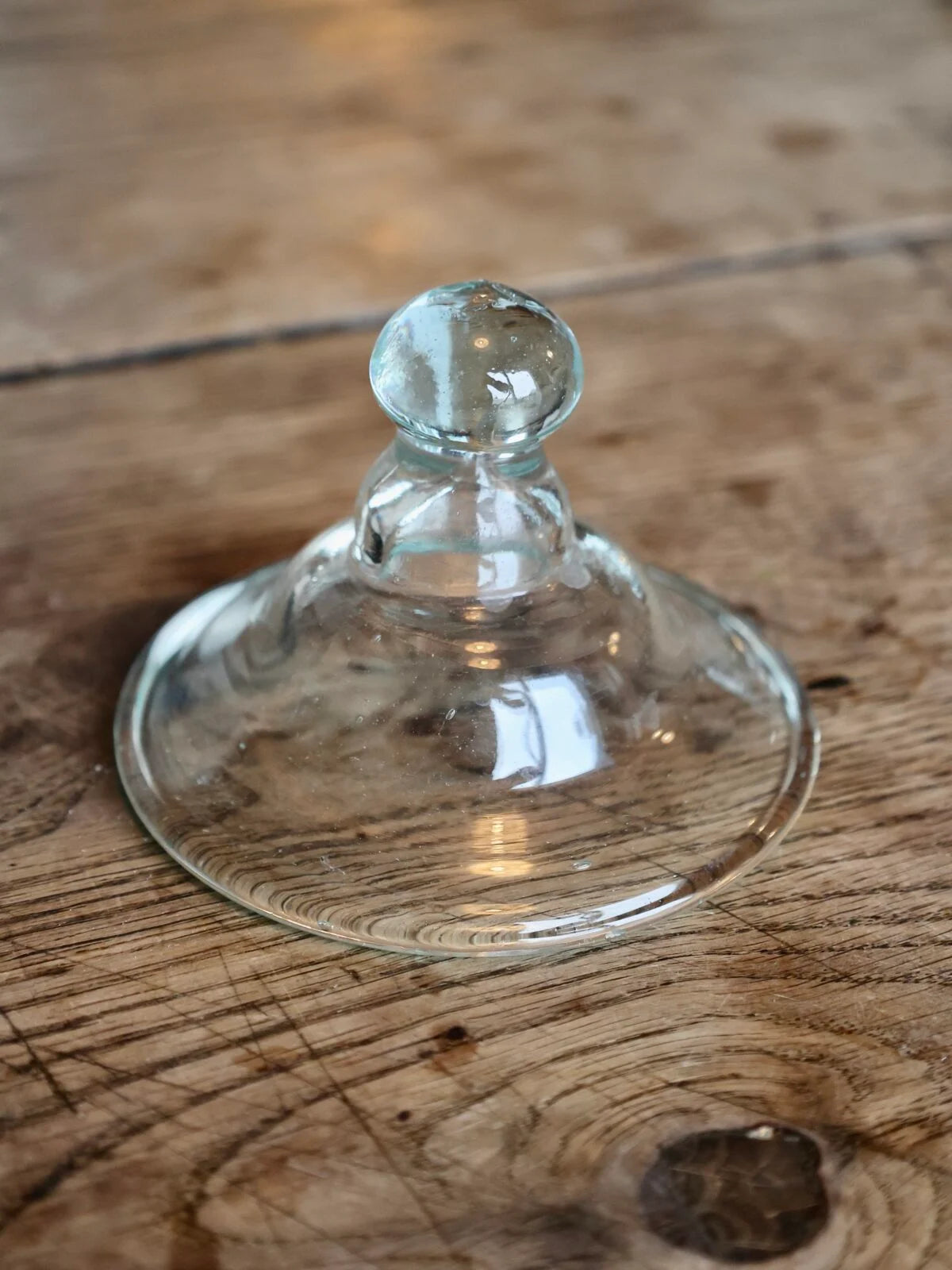 La Soufflerie Le Chapeau transparent recycled glass lid on a wooden surface
