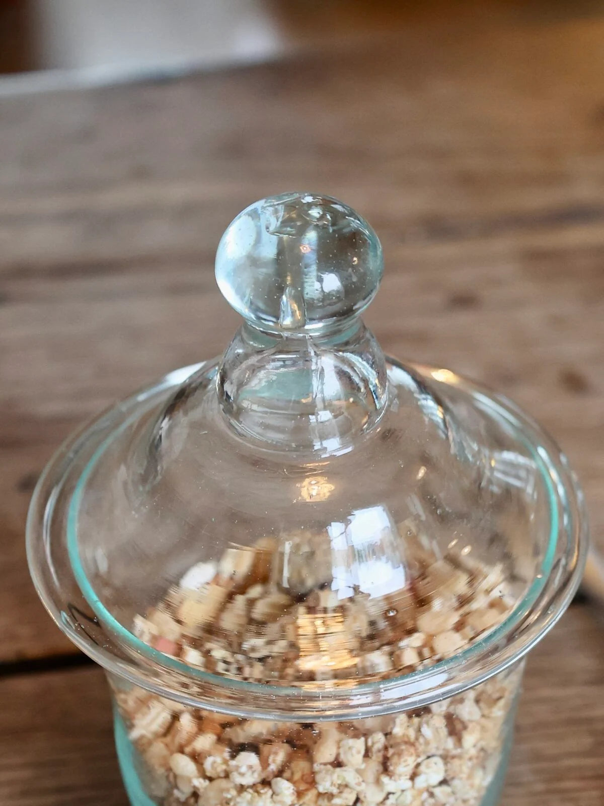 Glass jar with a decorative lid on a wooden surface