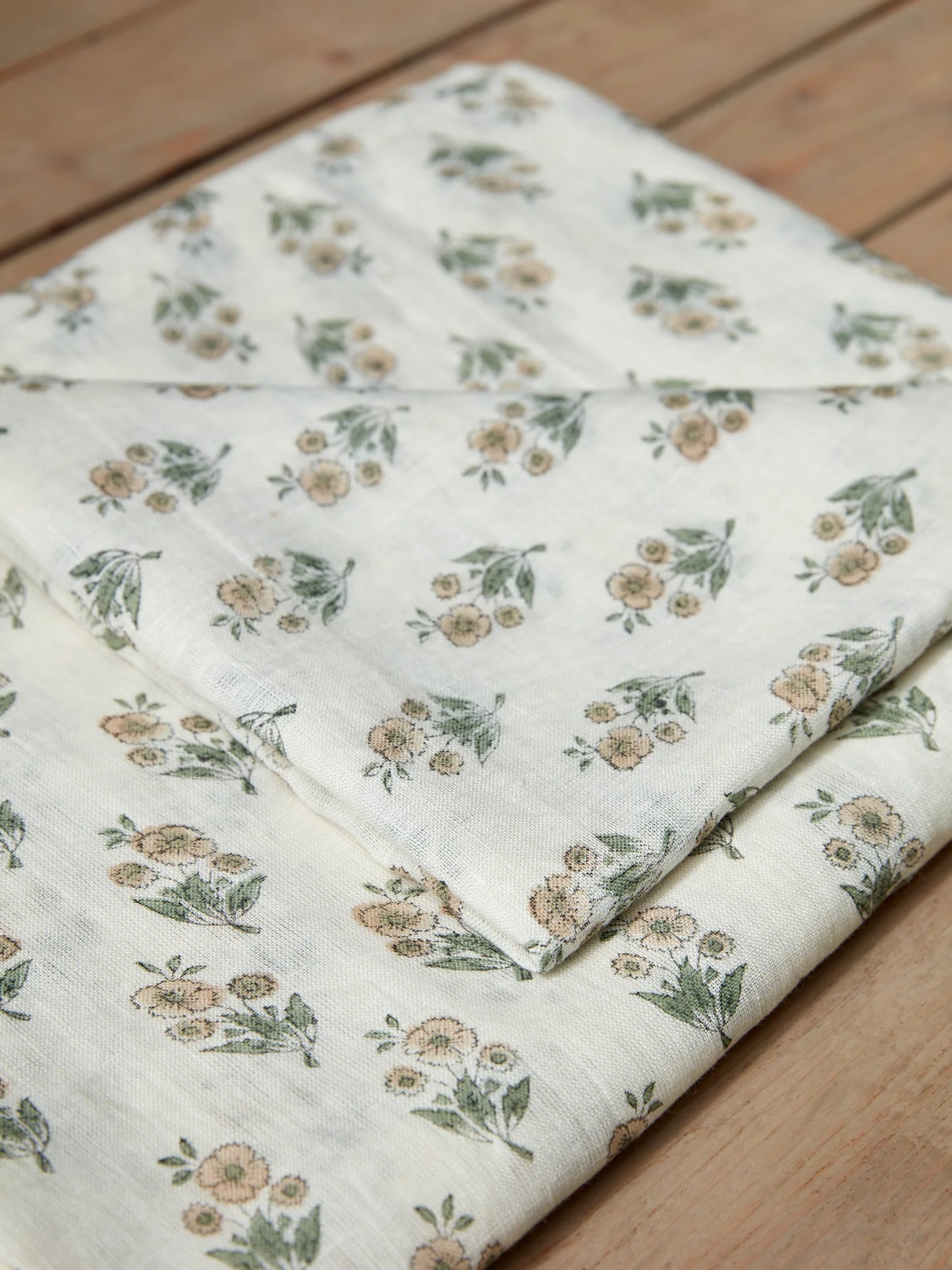 Floral-patterned linen tablecloth on a wooden surface