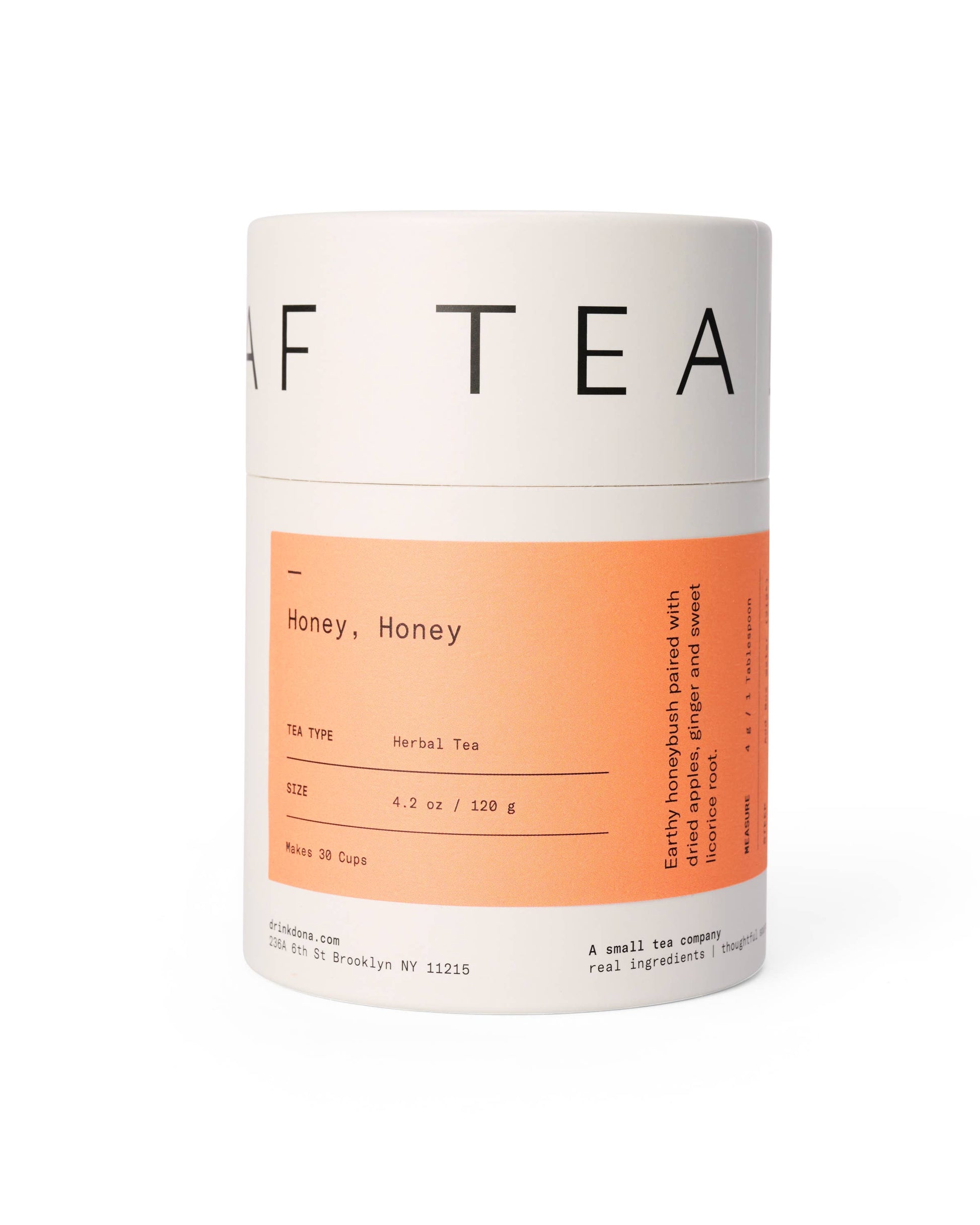 A cylindrical package labeled 'Honey Honey' herbal tea with text indicating the tea consists of dried leaves namely sage, lemongrass, rose petals, blue cornflower. It has a distinctive orange and white label design.