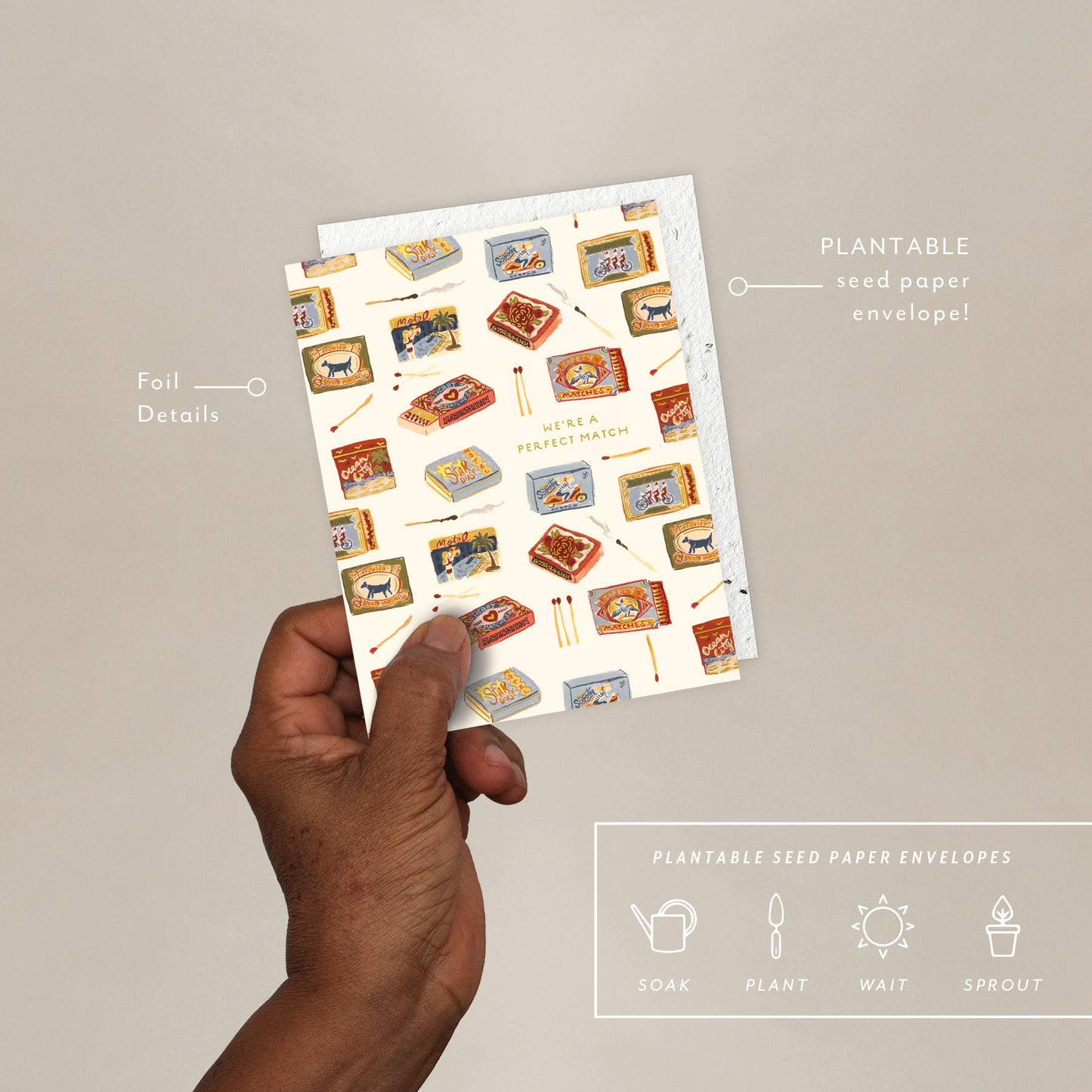 A hand holding a greeting card with an illustration displaying boxes of matches, accompanied by a plantable seed paper envelope with eco-friendly packaging details.