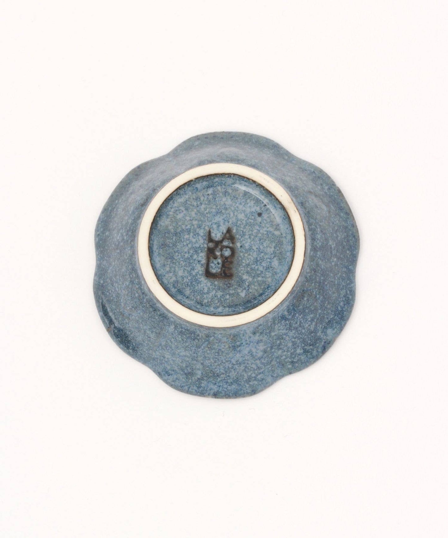 A ceramic mino ware mini bowl with a flower shape and a soft blue speckled glazed finishe, seen from the bottom on a white background.