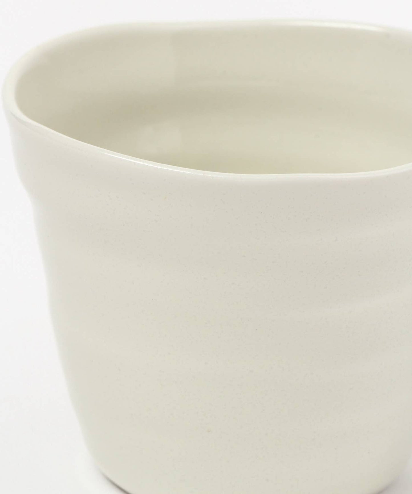 Close-up on a gloss white ceramic mino ware mug with an organic shape on a white background.