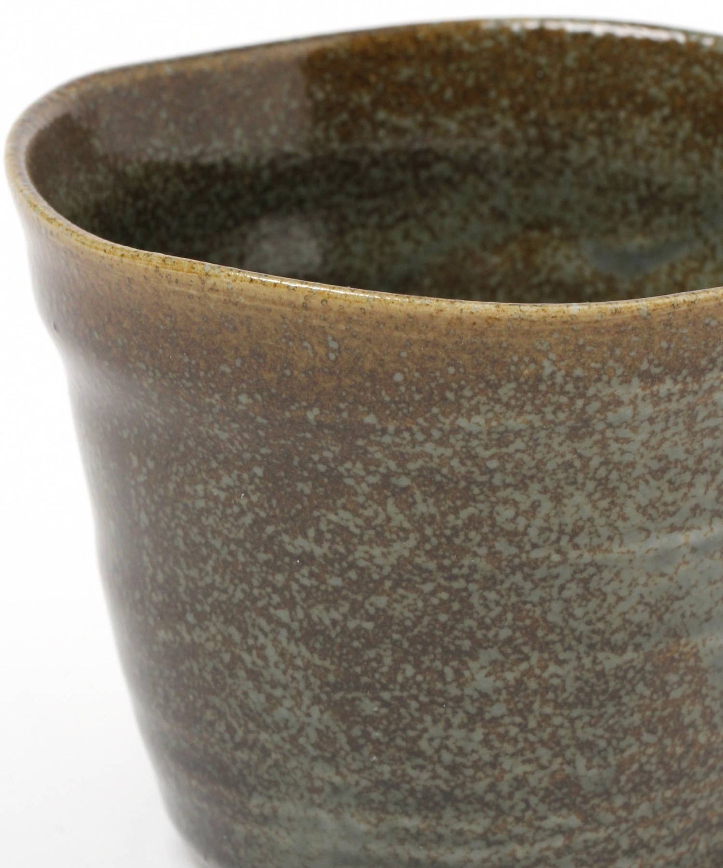 Close-up on a moss green ceramic mino ware mug with an organic shape on a white background.