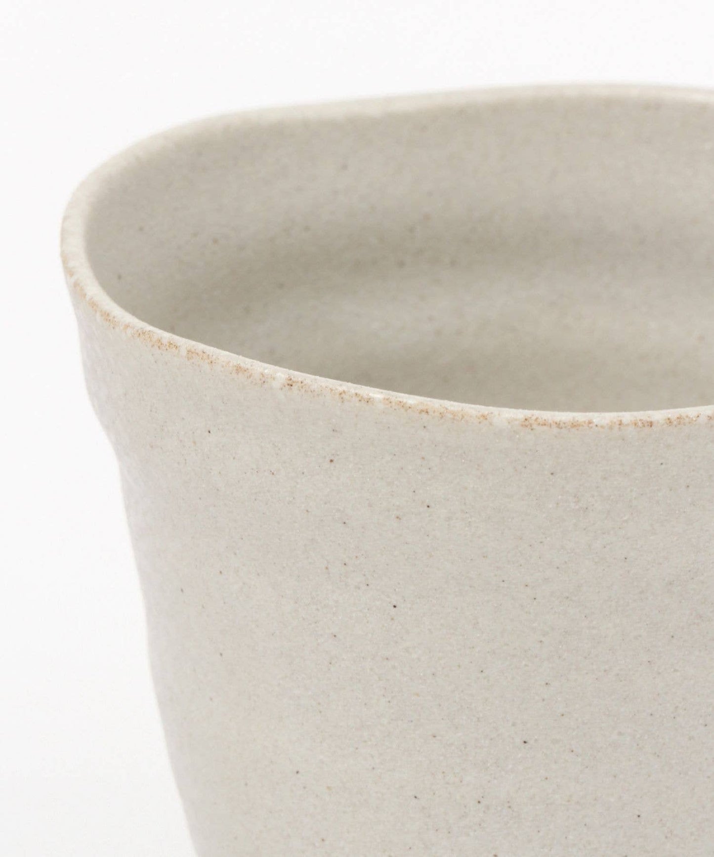 Close-up on a white ceramic mino ware mug with an organic shape on a white background.