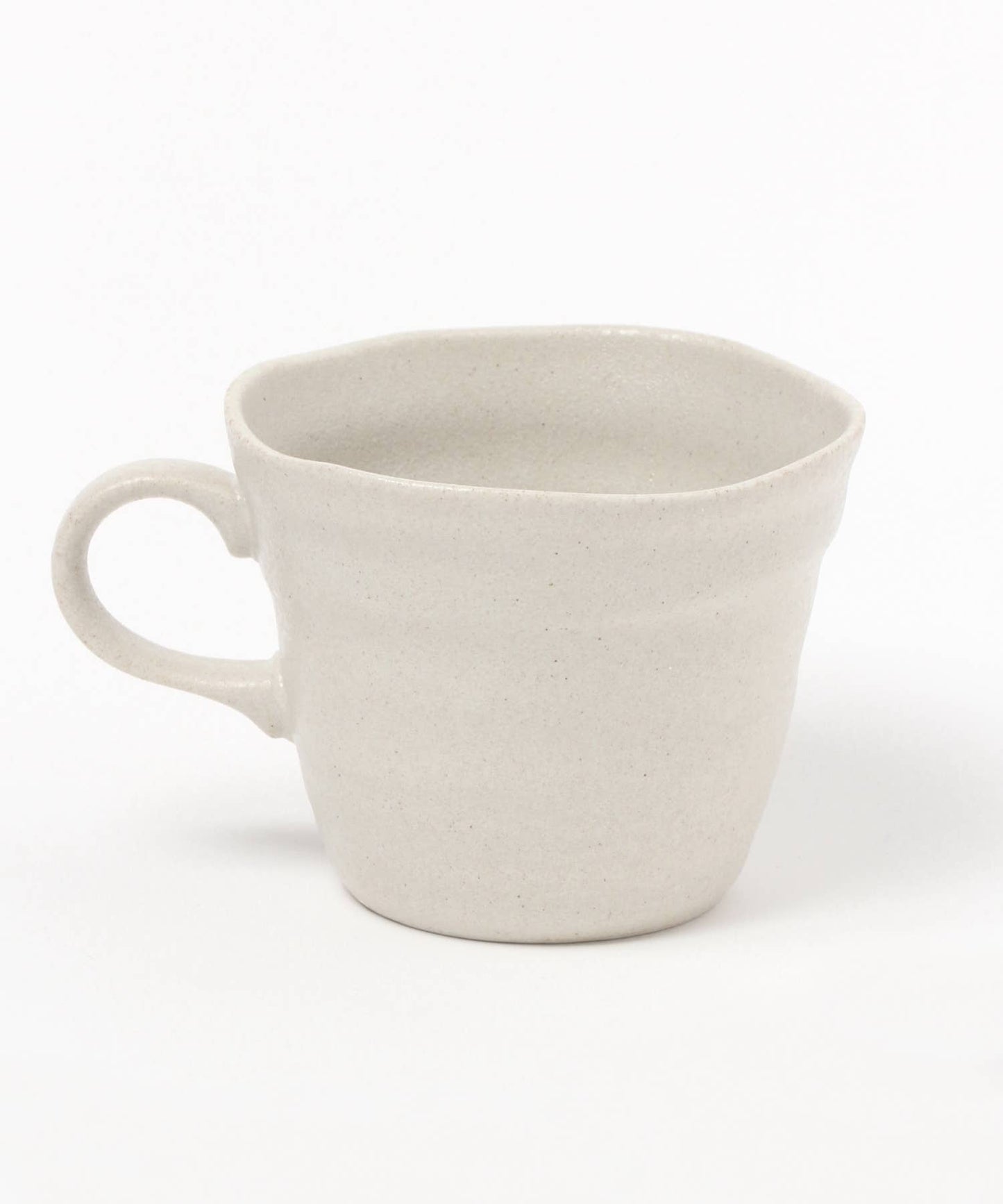 A white ceramic mino ware mug with an organic shape on a white background.
