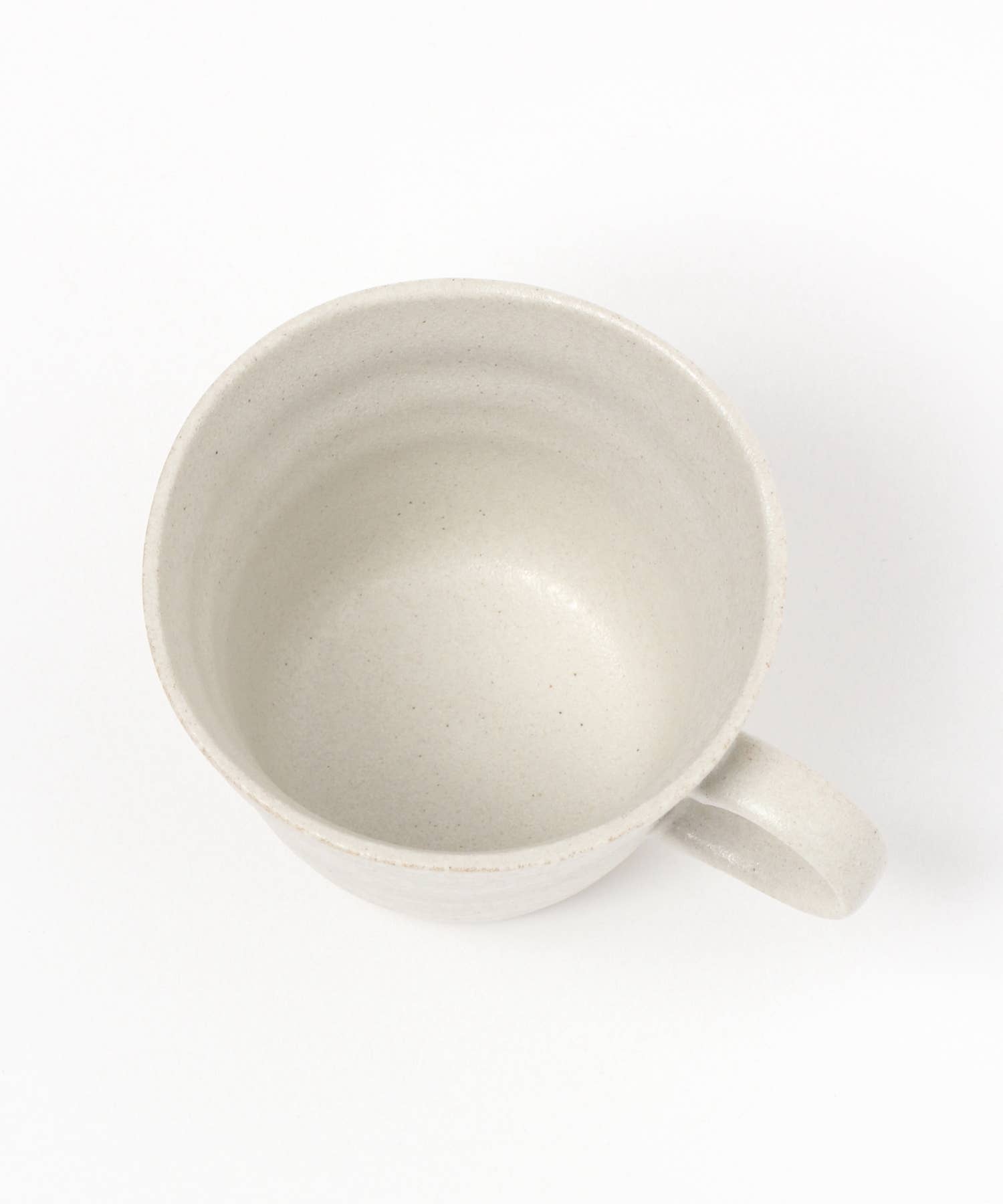 A white ceramic mino ware mug with an organic shape, seen from above, on a white background.
