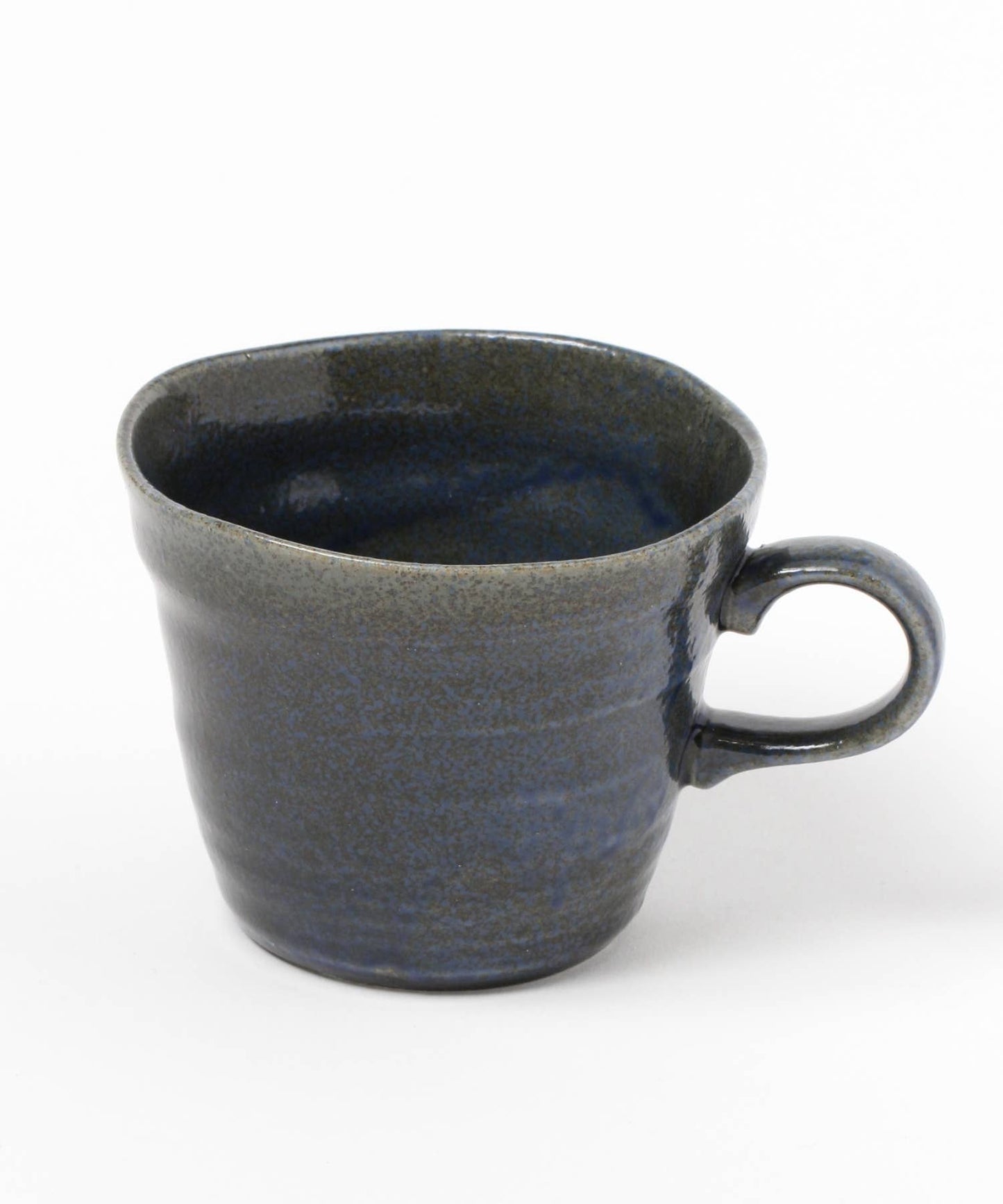 A dark blue ceramic mino ware mug with an organic shape on a white background.
