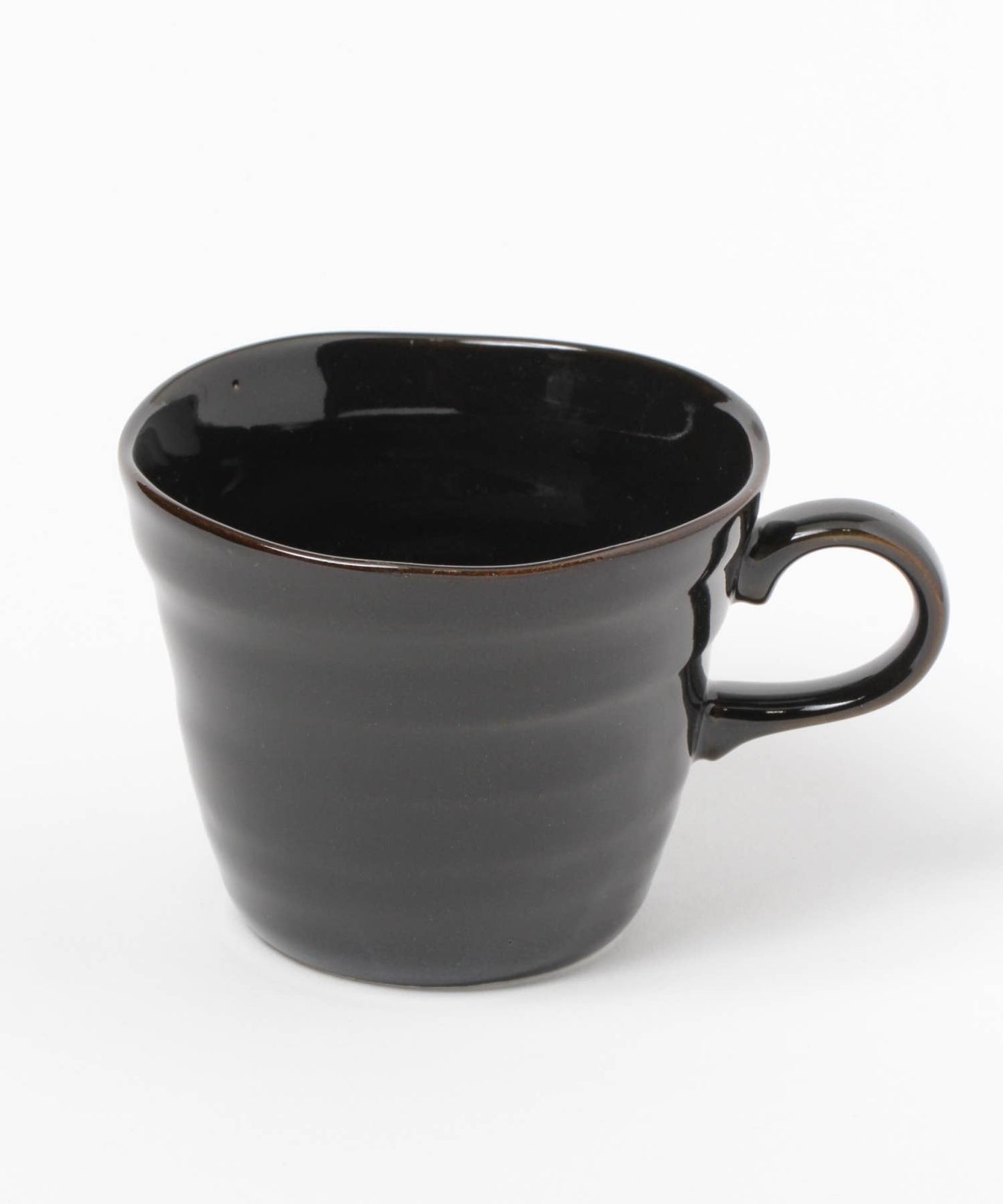 A gloss black ceramic mino ware mug with an organic shape on a white background.