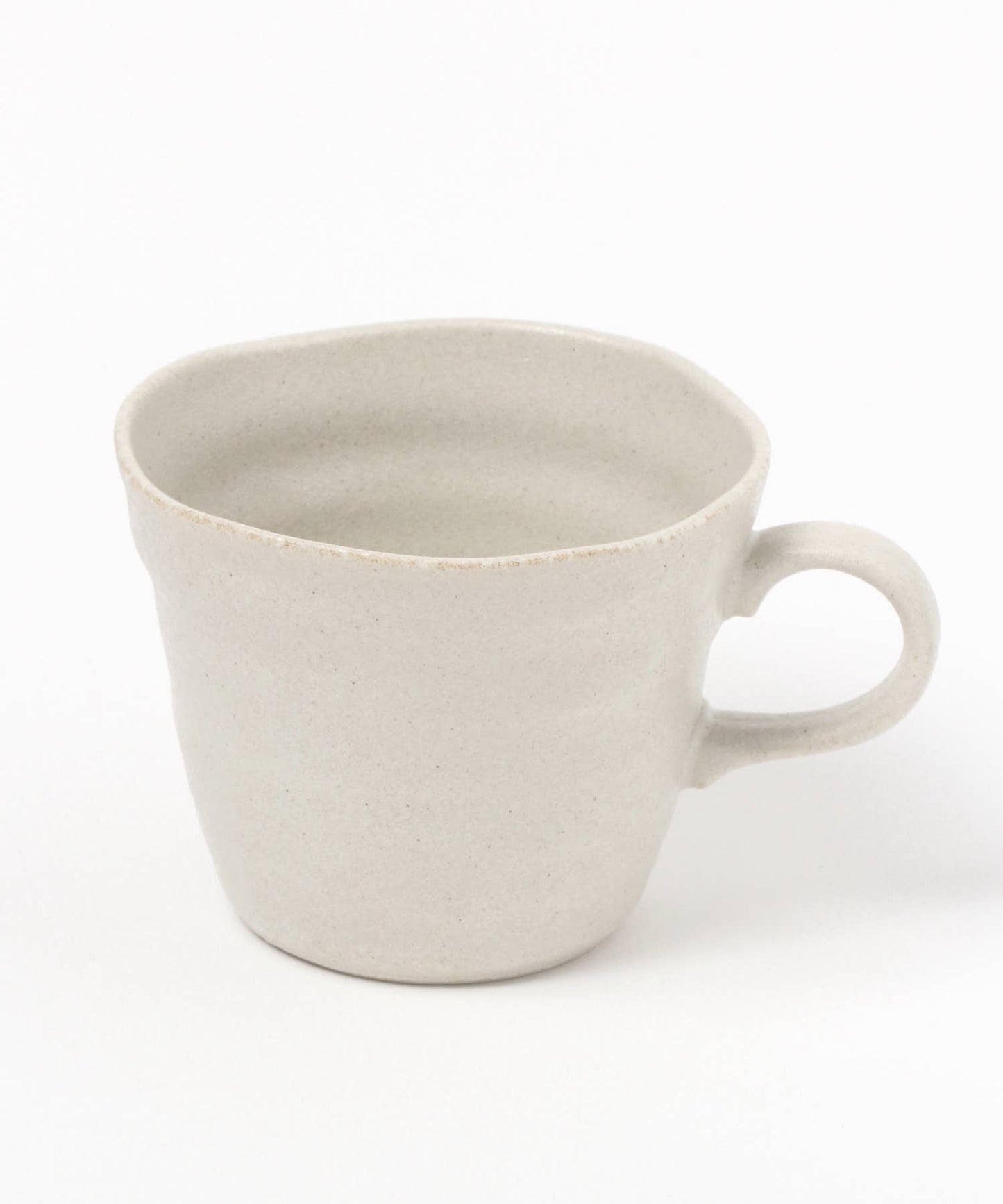 A white ceramic mino ware mug with an organic shape on a white background.