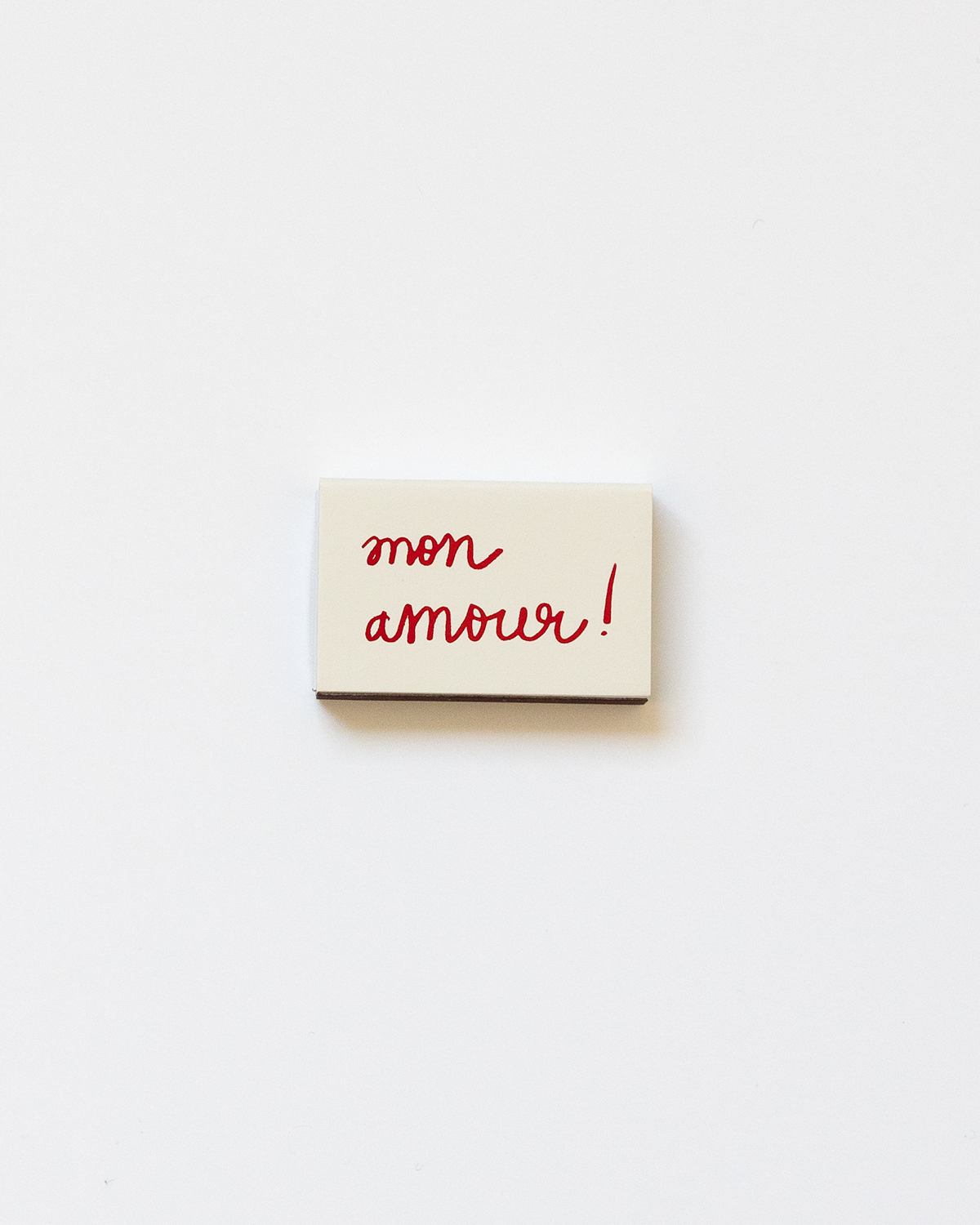 A beige-colored matchbox with the text 'Mon Amour', perfect for a cute gift.