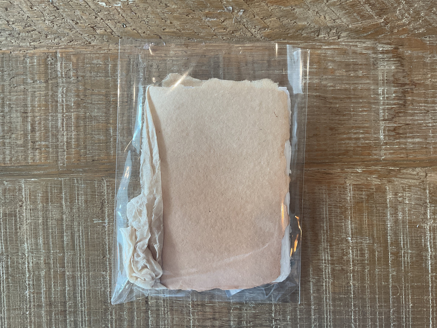 A handmade notebook with a cream silk ribbon and botanical-dyed cover in vanilla color.