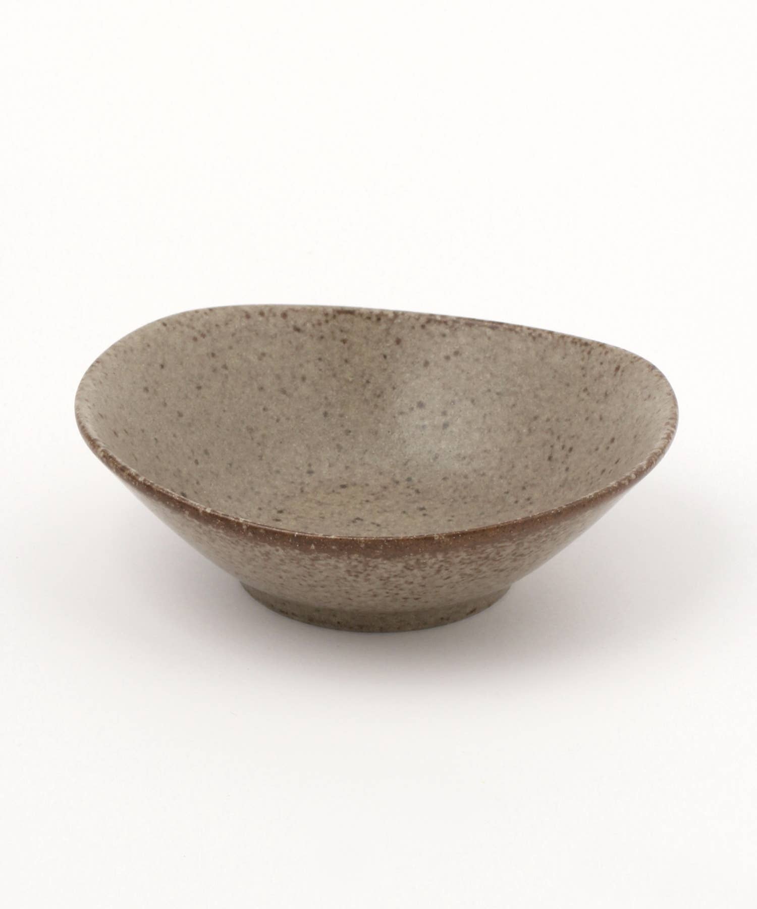 A beige ceramic mino ware mini bowl with an organic shape on a white background.