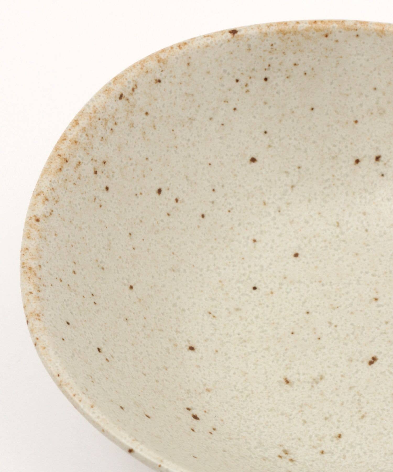 Close-up on a white ceramic mino ware mini bowl with an organic shape on a white background.