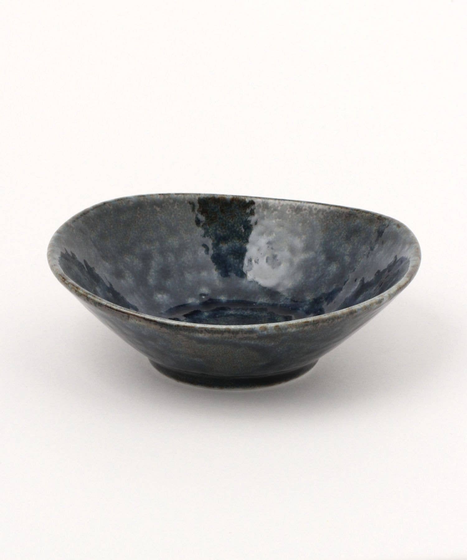 A dark blue ceramic mino ware mini bowl with an organic shape on a white background.