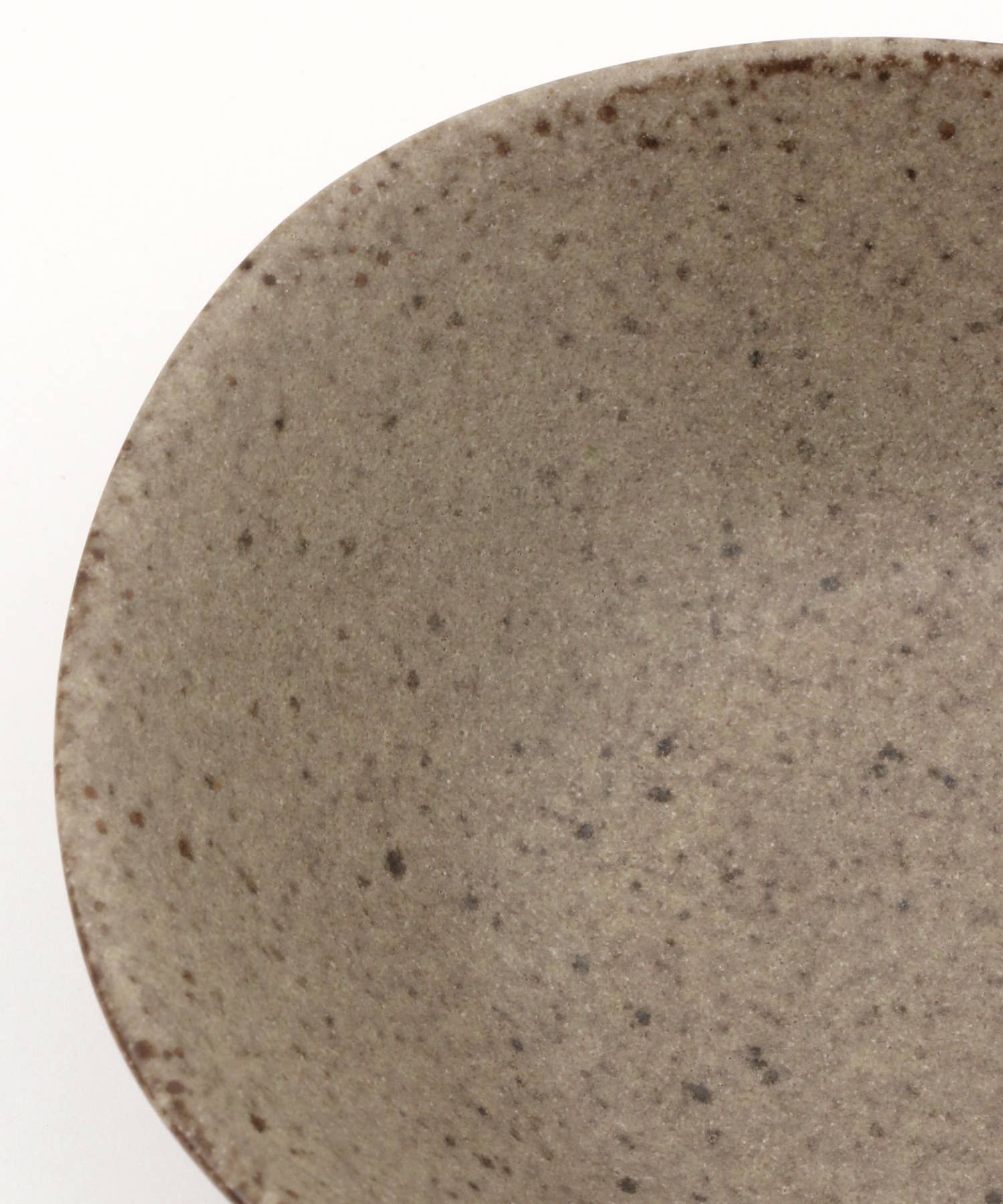 Close-up on a beige ceramic mino ware mini bowl with an organic shape on a white background.