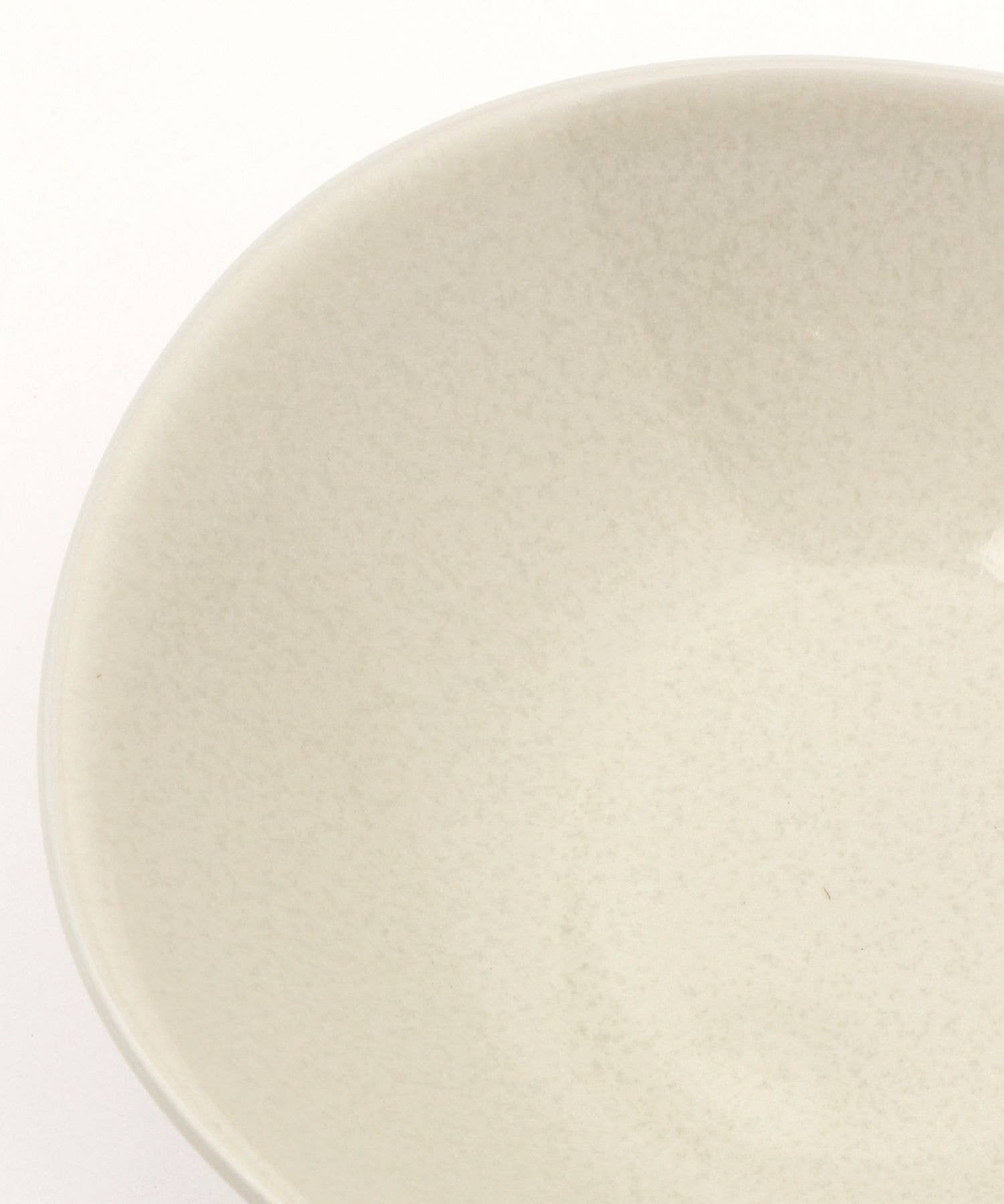 Close-up on a gloss white ceramic mino ware mini bowl with an organic shape on a white background.