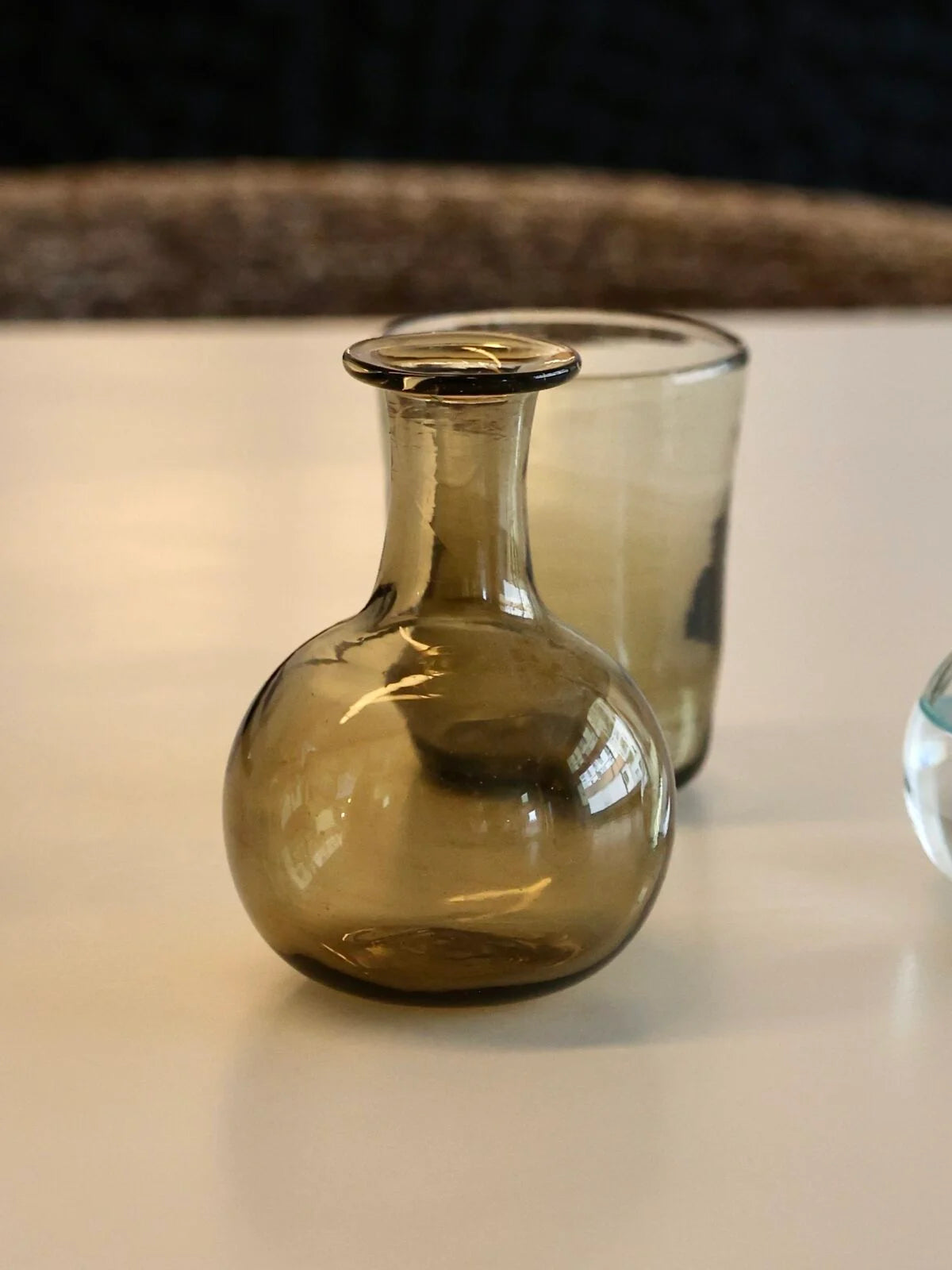 Elegant brown petite vase for single flower or bud display, on a reflective surface with a dark background