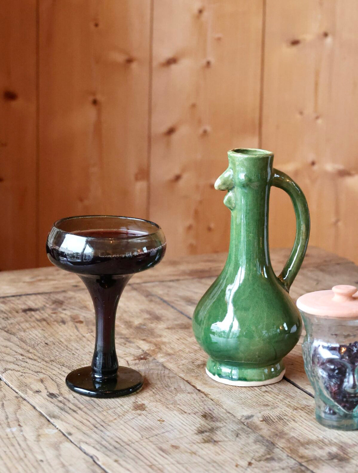 Playful green ceramic chicken-shaped jug on a wooden surface