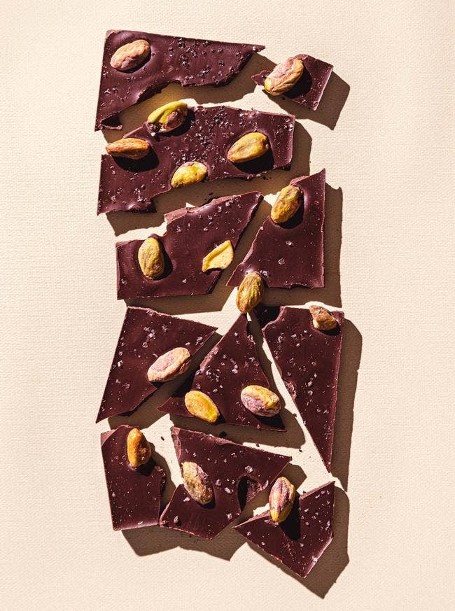 Dark chocolate with pistachios on a beige background
