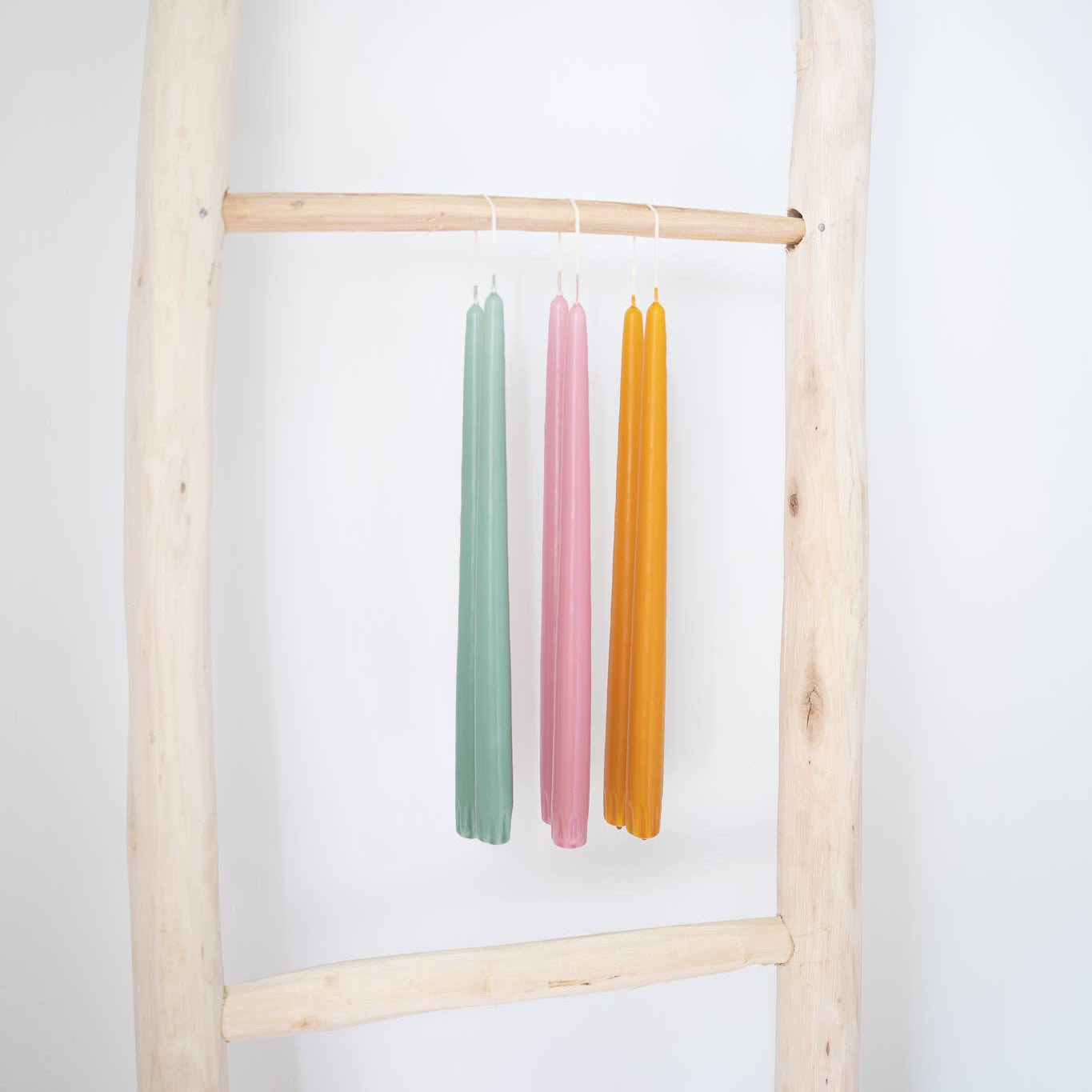 Taper candles pairs in various colors: a blue green, a pink and a harvest gold.