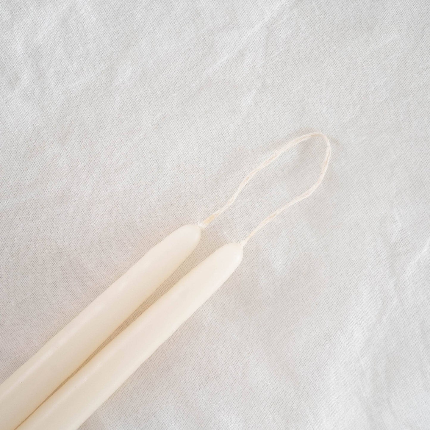Close-up on a pair of hand-dipped ivory taper candles