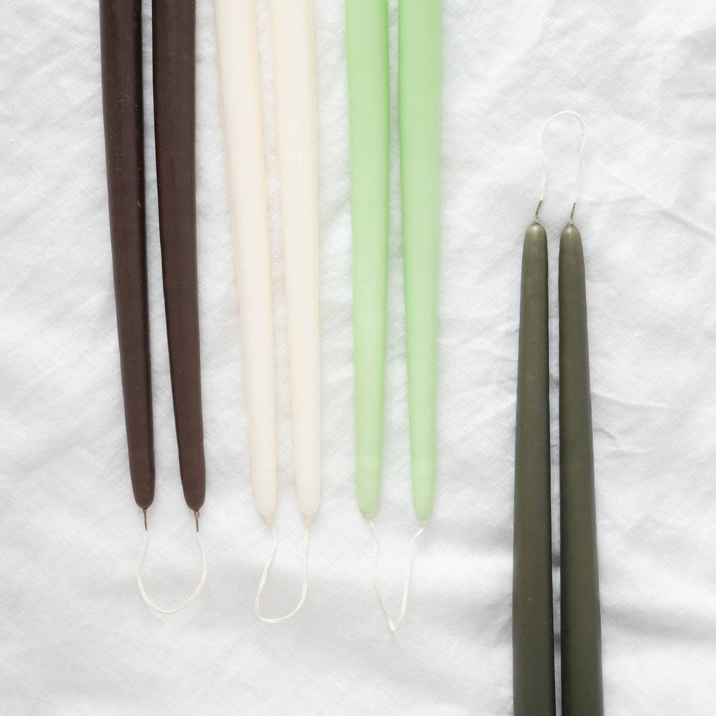 Hand-dipped taper candles pairs in various colors: brown, ivory, light green  and olive.